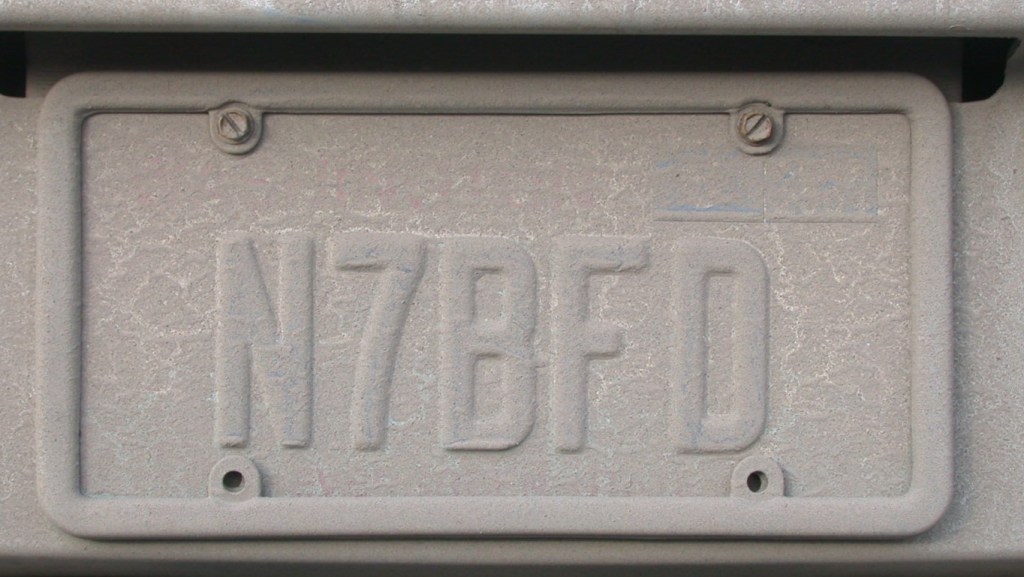 A dirty embossed Washington state license plate