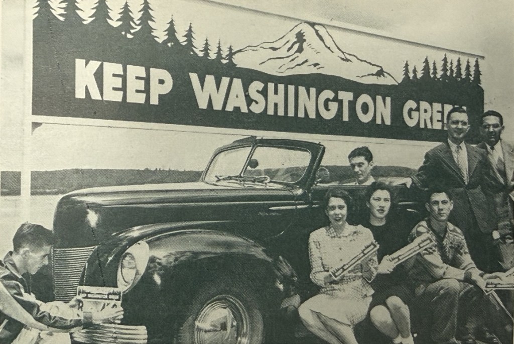 Keep Washington Green license plate toppers on display with a car and Keep Washington Green billboard, 1948