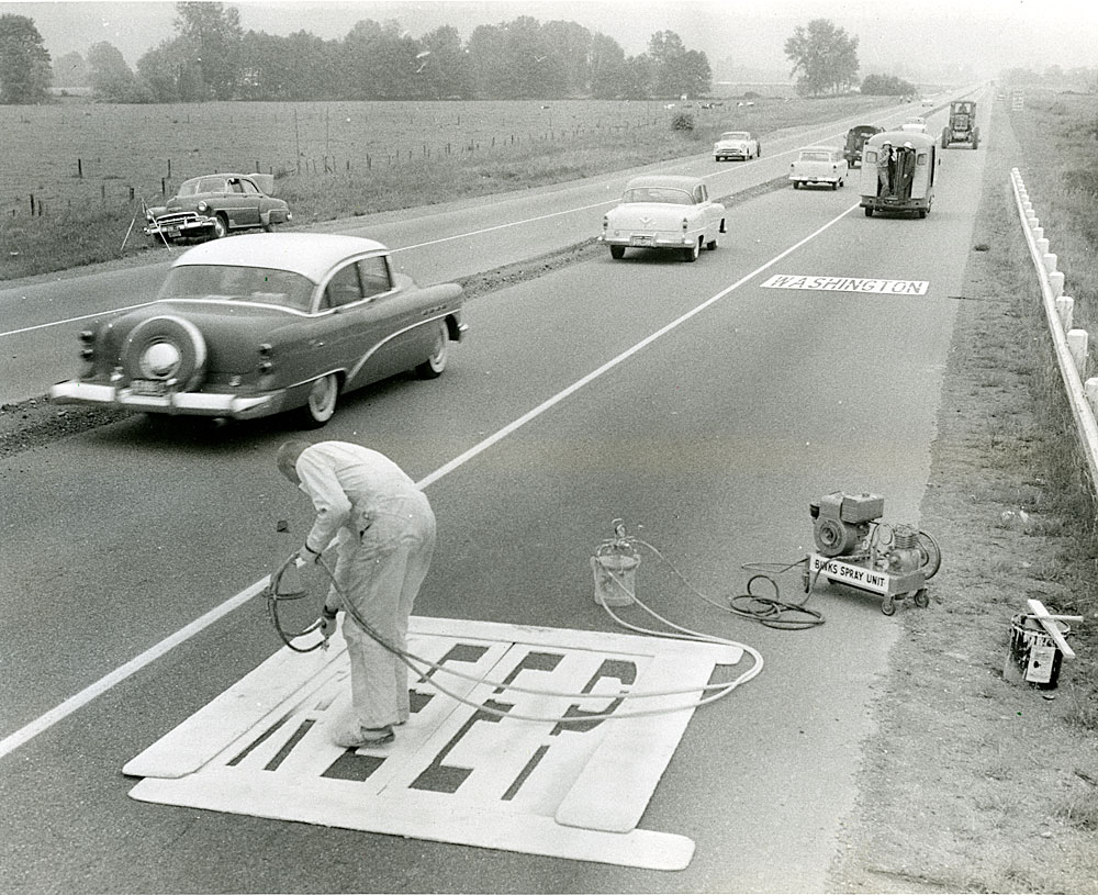 Stenciling Washington state highway with the message "Keep Washington Green"